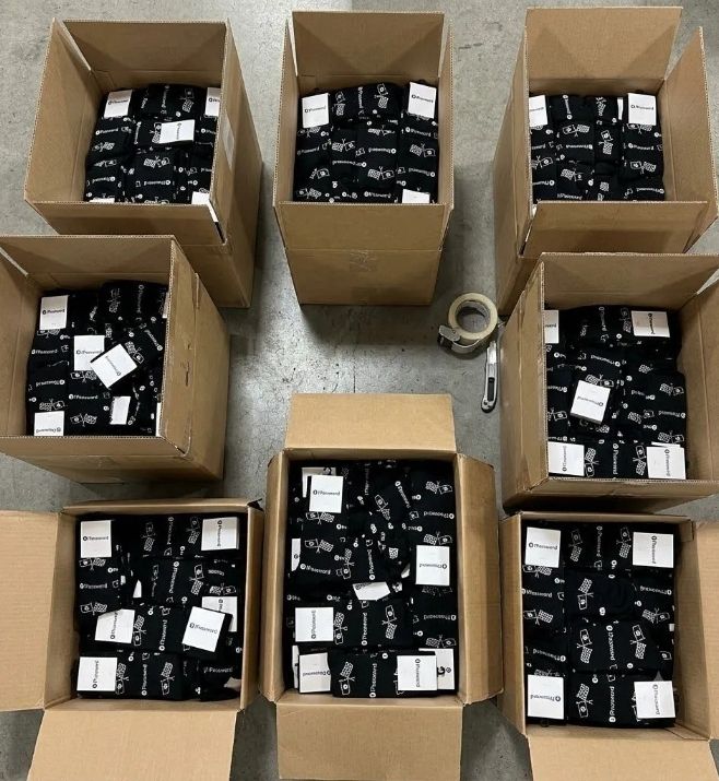 Open cartons filled with packaged 1Password custom socks