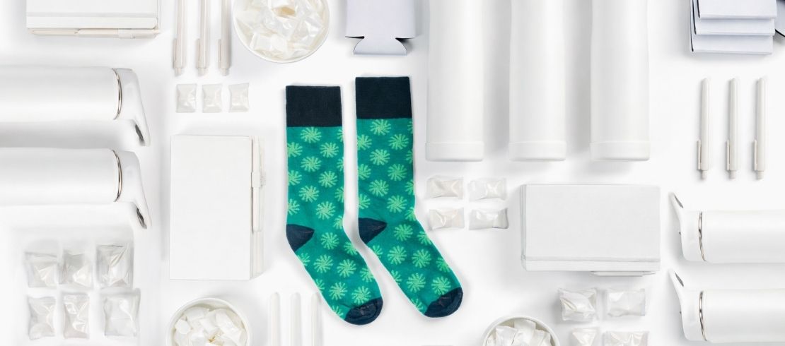 Green custom socks surrounded by white conference giveaway items