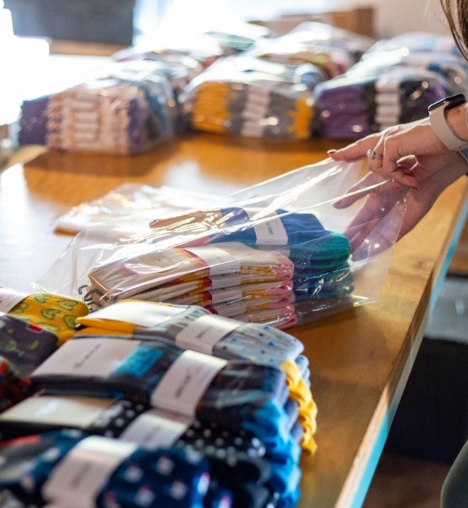 Team member packing colorful custom socks for an event