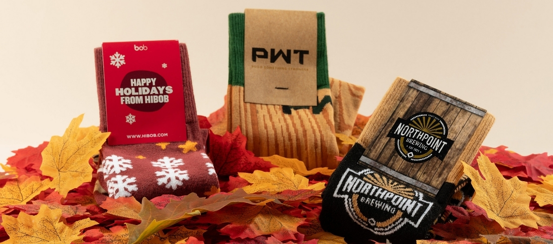 Custom fall socks displayed among colorful autumn leaves