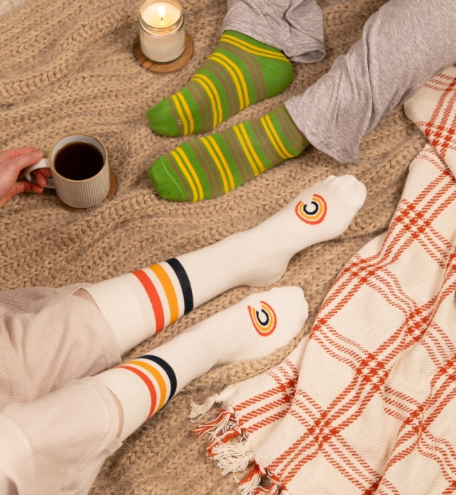 Two pairs of custom striped socks styled for a cozy fall setting