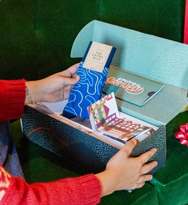 Recipient opening a custom holiday gift box with socks and printed inserts