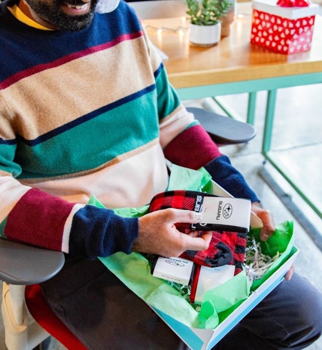 Employee opening a holiday gift box containing custom socks
