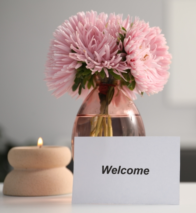 Welcome card displayed with flowers and a candle