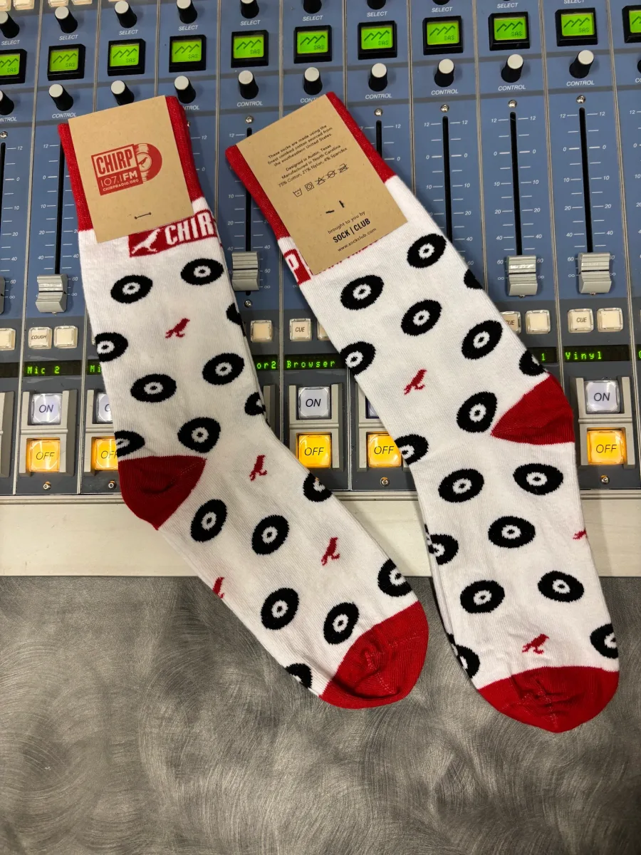 Custom CHIRP Radio socks displayed on a radio station mixing console